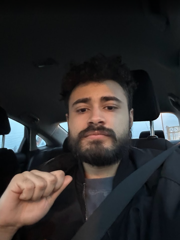 Angel seated in a car in a close portrait.