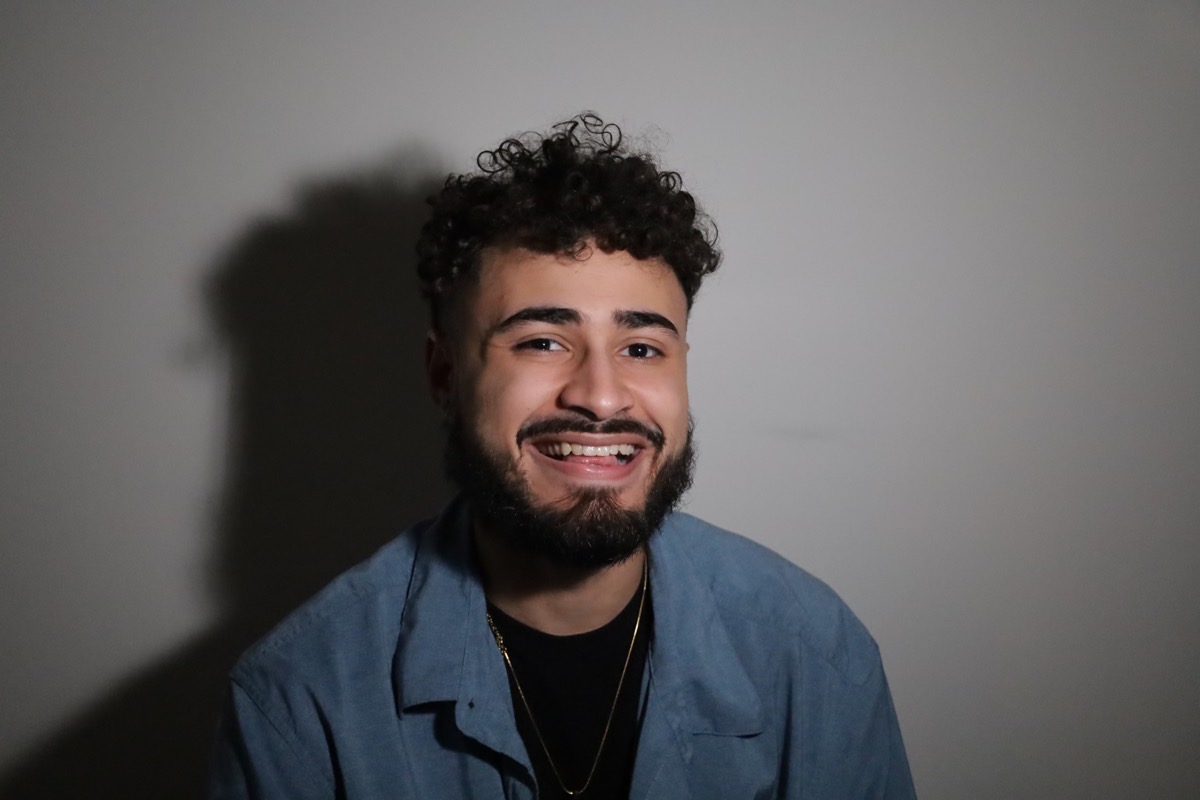 Angel Suero smiling against a neutral wall